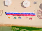 На пляже Анапы развернули 100-метровый российский триколор: в городе отмечают день флага России