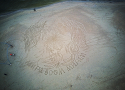 «Мира всем мирам»: анапский художник Леонид Валитов создал новый шедевр на песке